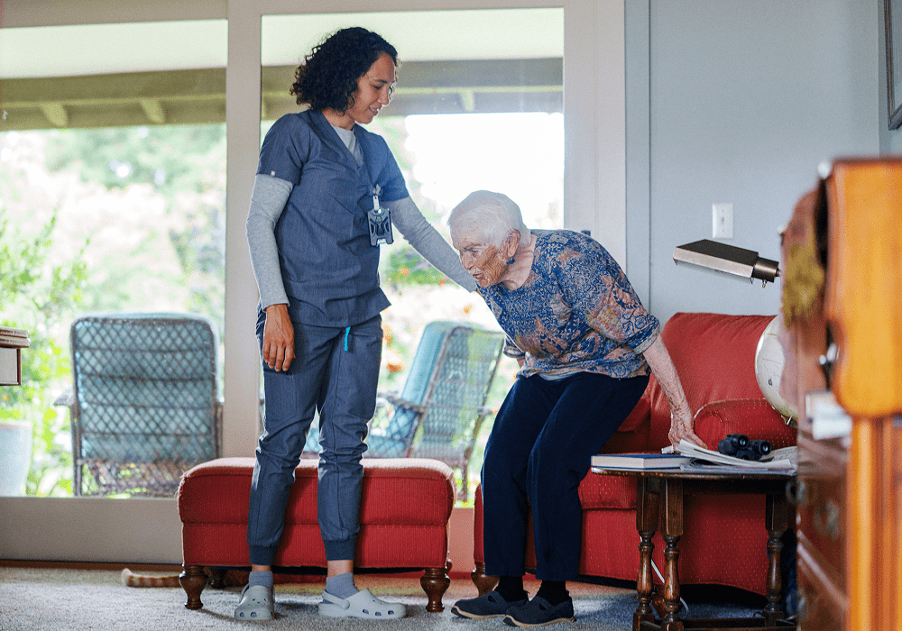Nurse helping senior woman stand up.